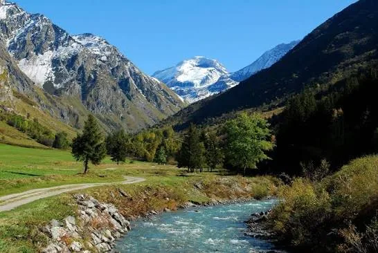 Champagny-le-Haut upper valley with a turquoise stream, meadow path and snow-capped peaks
