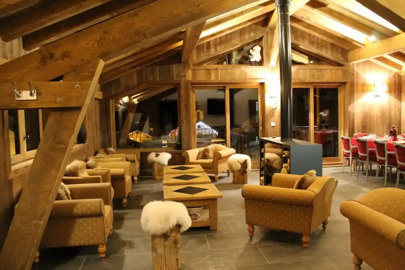 La Datcha wooden lounge with armchairs, dining table and a freestanding wood-burning stove